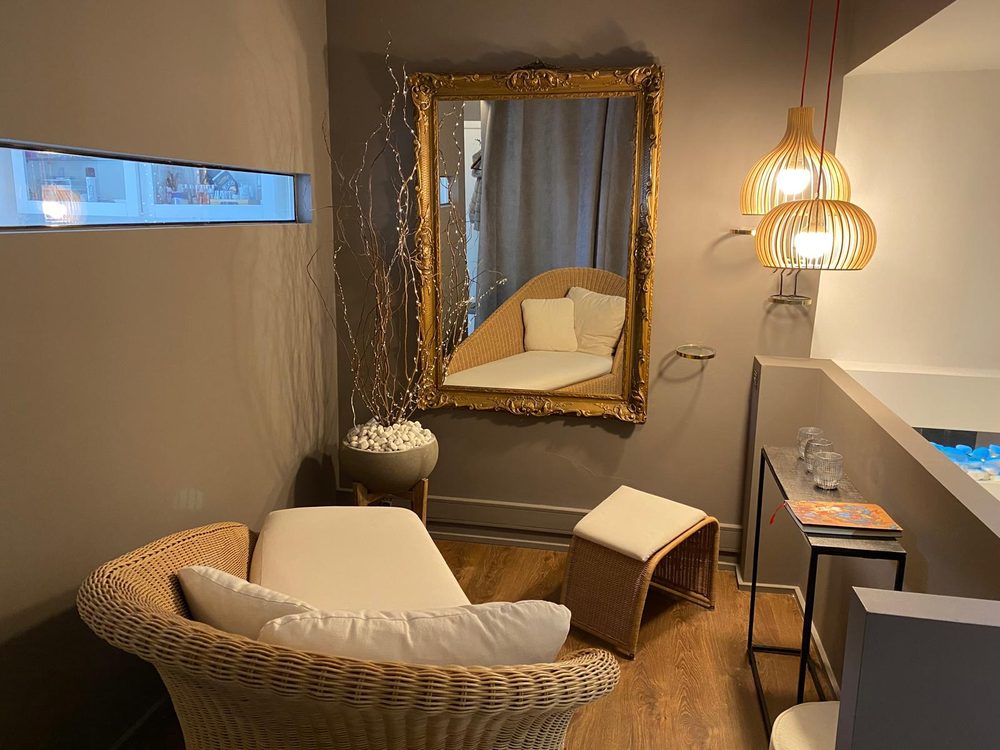 Relaxation corner with wicker chair and golden mirror